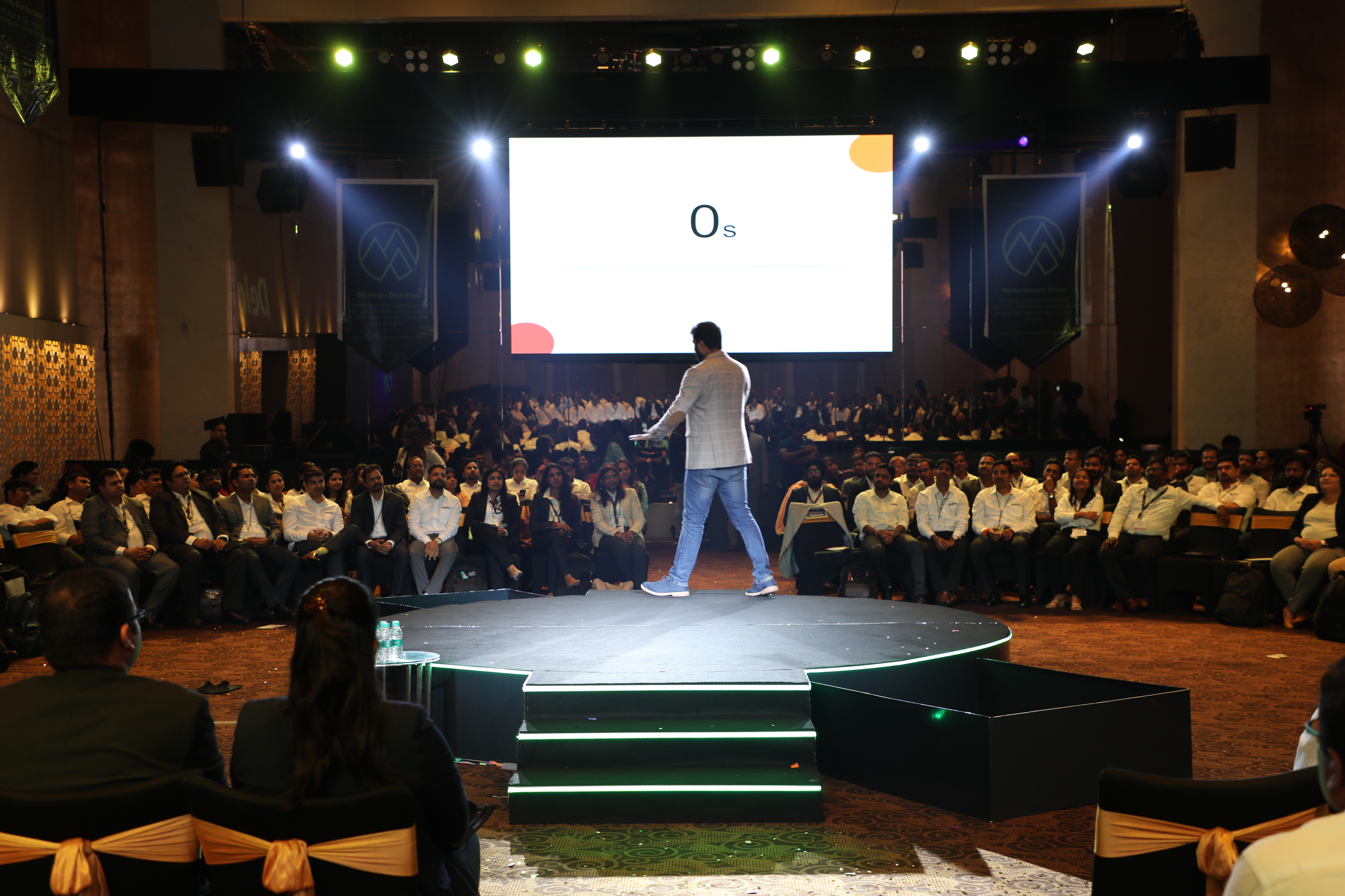 Saveen Hegde speaking to a large audience